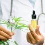 A researcher holding a bottle of hemp oil.