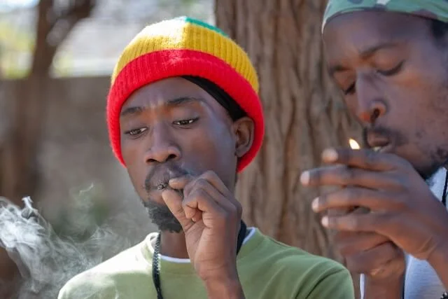 African man smoking a marijuana joint.