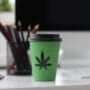 Coffee cup with a cannabis logo against an office background