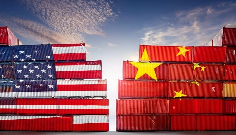 Stacks of cargo containers painted with the U.S. and Chinese flags facing off, representing the trade war and tariff tensions.