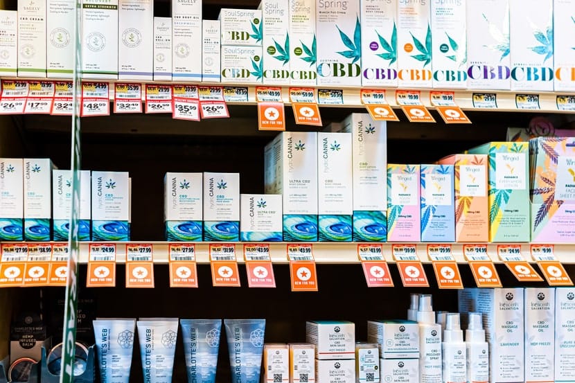 Retail shelf filled with various branded CBD skincare products, including creams, serums, and body care items.