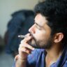 A stylish Indian youth smoking marijuana joint