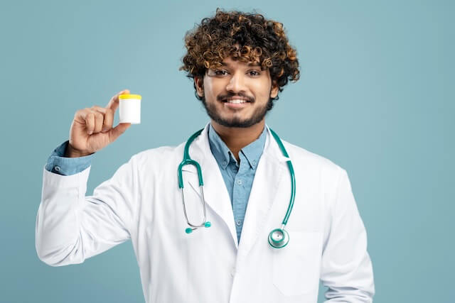 Indian doctor holding a container of medicinal cannabis
