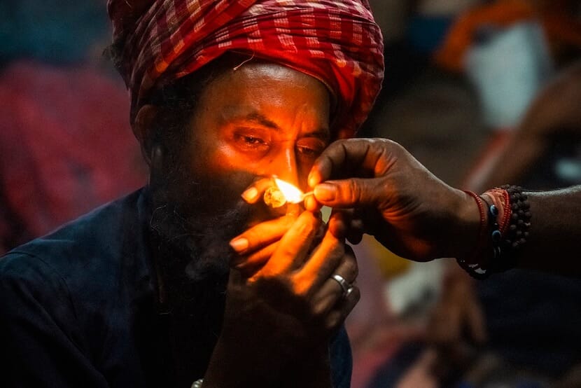 Sadhu man smoking cannabis pipe in India
