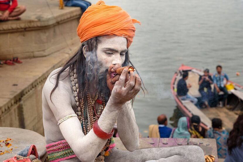 A Sadhu man smoking ganja on the streets of Varansi